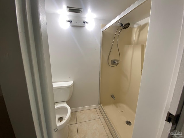 bathroom with toilet, an enclosed shower, and tile patterned floors