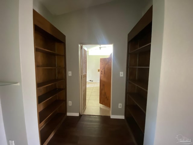 hall with built in shelves and dark hardwood / wood-style floors