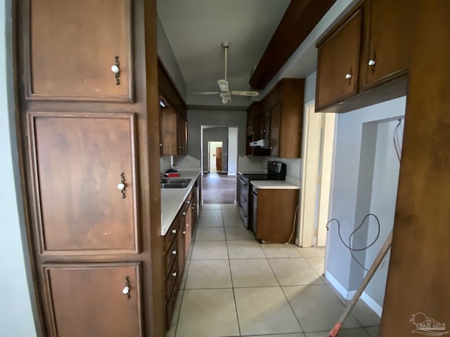 kitchen with black range with electric stovetop, sink, light tile patterned floors, and ceiling fan