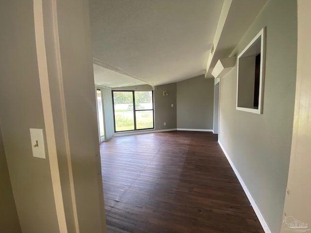 empty room with lofted ceiling and dark hardwood / wood-style floors