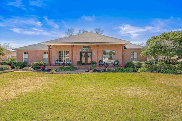 view of front of house with a porch, a front lawn, and brick siding