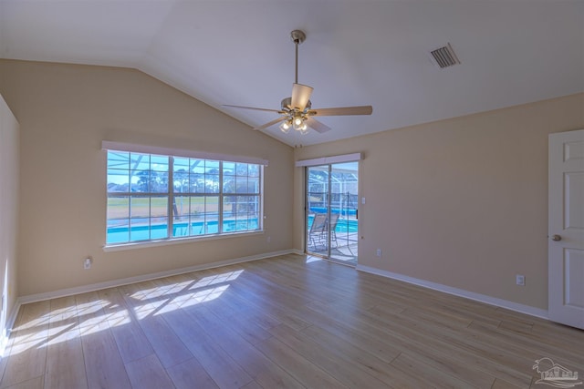 unfurnished room featuring lofted ceiling, visible vents, light wood-style flooring, a ceiling fan, and baseboards