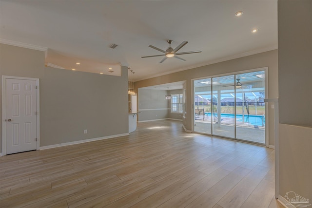 spare room with light wood-style flooring, visible vents, and ornamental molding