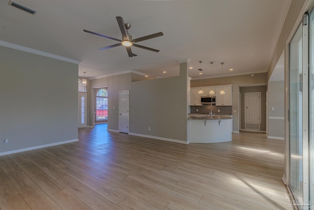 unfurnished living room featuring ceiling fan, light wood-type flooring, visible vents, and baseboards