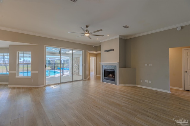 unfurnished living room with a ceiling fan, a tile fireplace, baseboards, and light wood finished floors