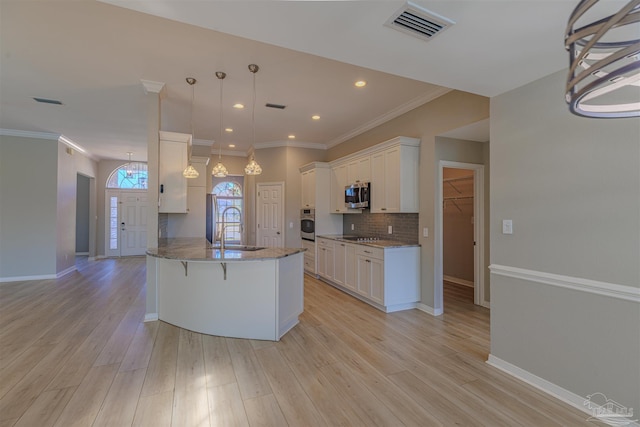 kitchen with visible vents, white cabinetry, stainless steel appliances, and pendant lighting