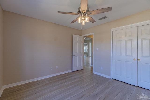 unfurnished bedroom featuring visible vents, baseboards, a ceiling fan, light wood-type flooring, and a closet