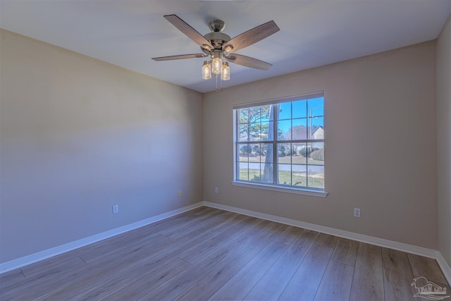 unfurnished room featuring a ceiling fan, baseboards, and light wood finished floors