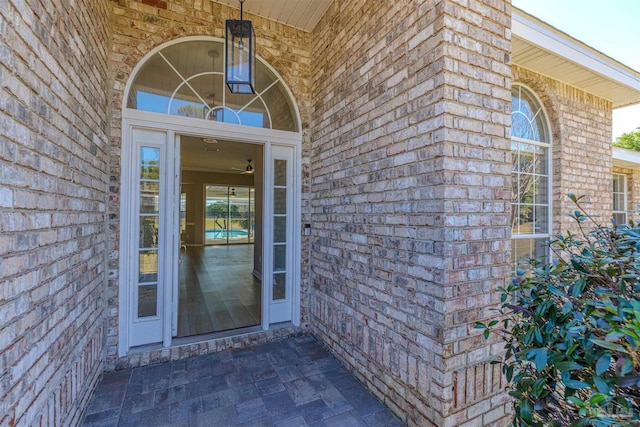 view of exterior entry featuring brick siding