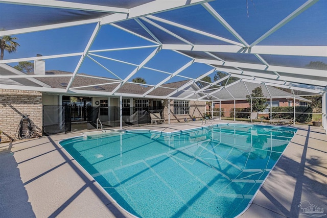 pool featuring glass enclosure and a patio