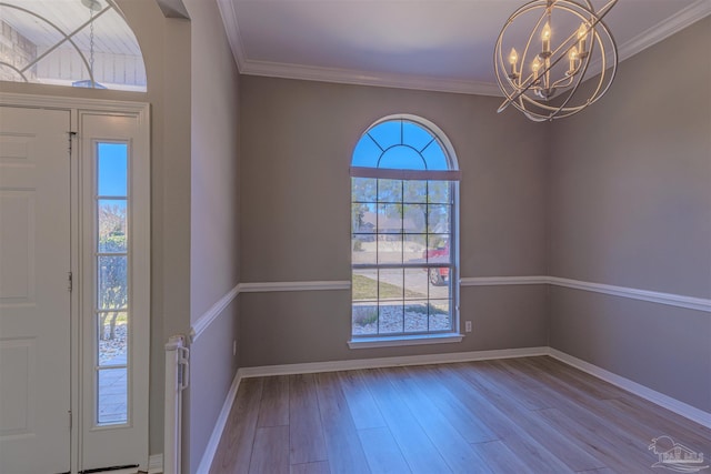 foyer entrance with light wood finished floors, baseboards, and crown molding