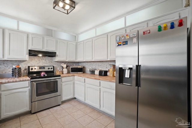 kitchen featuring appliances with stainless steel finishes, light tile patterned floors, tasteful backsplash, and white cabinetry