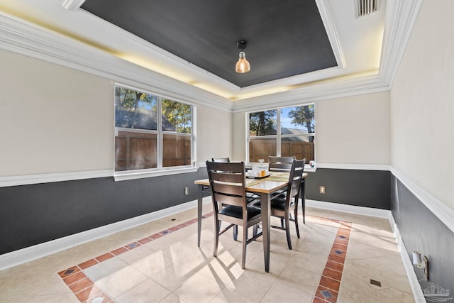 dining area featuring light tile patterned floors and a raised ceiling