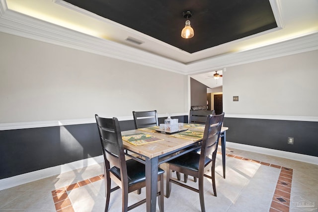 dining area featuring a raised ceiling, ceiling fan, crown molding, and light tile patterned floors