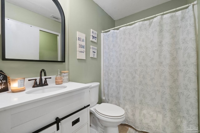 bathroom featuring vanity, toilet, and walk in shower