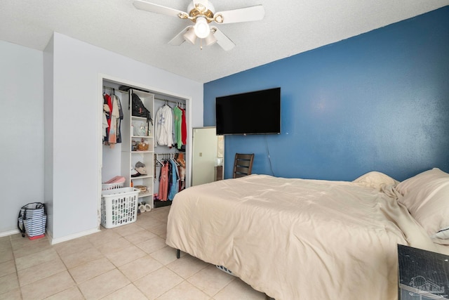 tiled bedroom with ceiling fan, a textured ceiling, and a closet