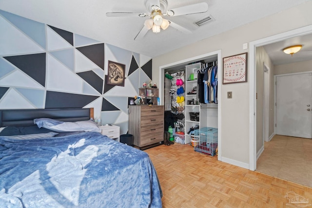 bedroom with ceiling fan, a closet, and light parquet floors