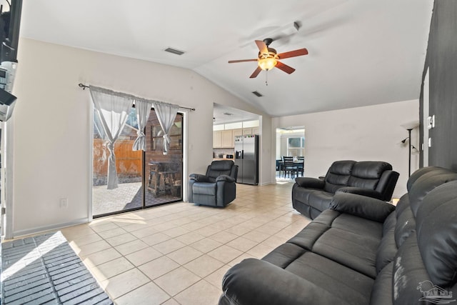 living room featuring plenty of natural light, light tile patterned flooring, lofted ceiling, and ceiling fan