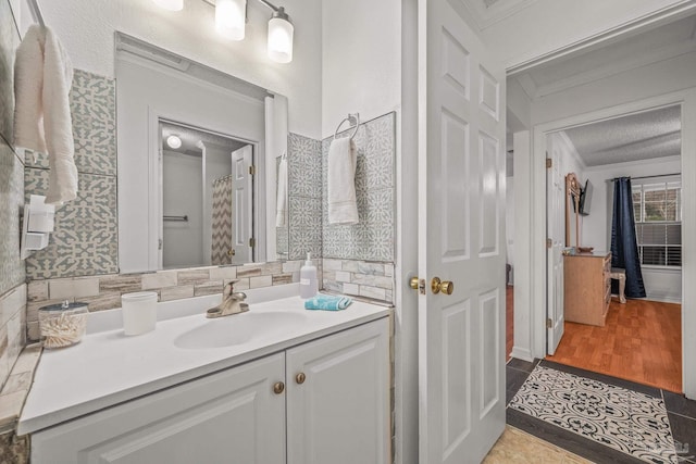 full bathroom featuring tile patterned flooring, decorative backsplash, vanity, and crown molding