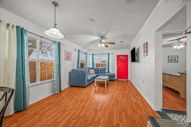 unfurnished living room with light wood-style floors, ceiling fan, crown molding, and a textured ceiling