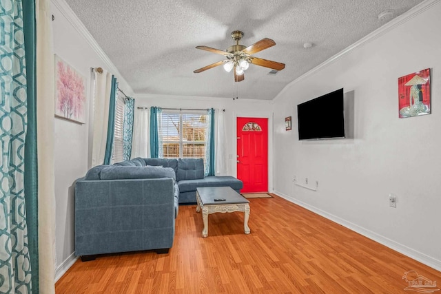 living room with ornamental molding, a textured ceiling, light wood-style floors, baseboards, and ceiling fan