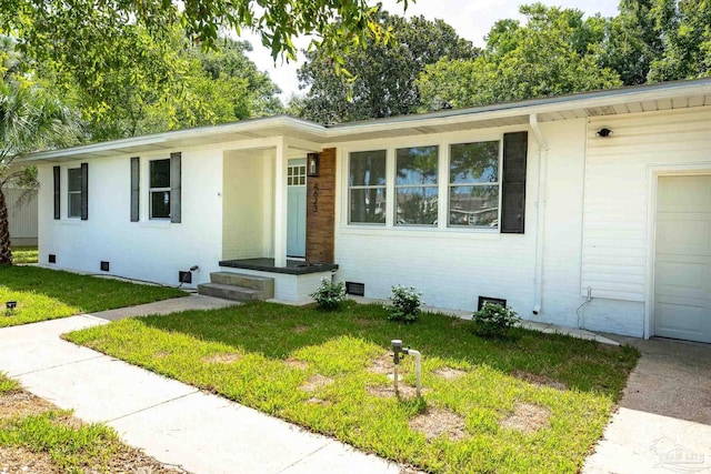 ranch-style home featuring a garage and a front yard