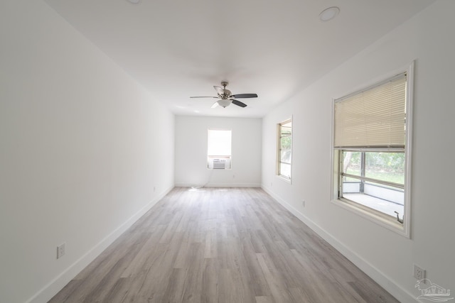 empty room with cooling unit, light hardwood / wood-style floors, and ceiling fan