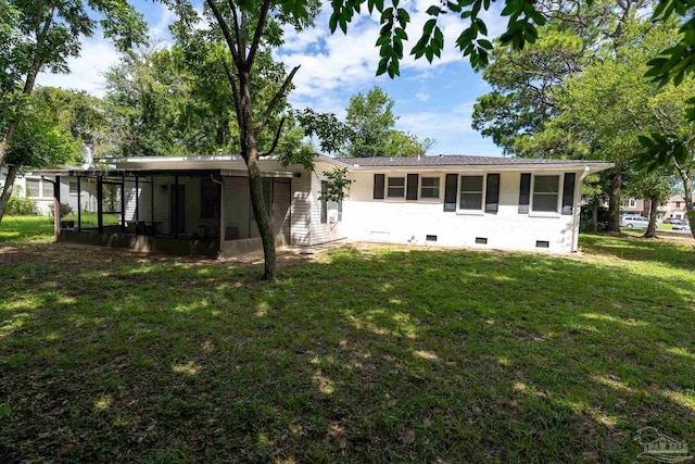 rear view of property featuring a yard and a sunroom