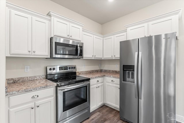 kitchen featuring light stone counters, white cabinetry, stainless steel appliances, and dark hardwood / wood-style floors