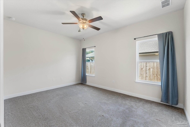 carpeted spare room featuring ceiling fan