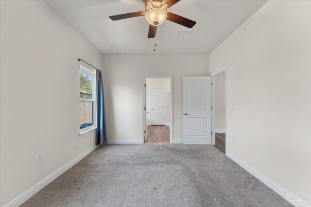 unfurnished room with ceiling fan and light colored carpet