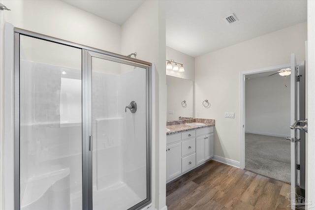 bathroom with hardwood / wood-style floors, vanity, ceiling fan, and a shower with door