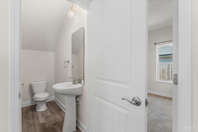 bathroom with sink, hardwood / wood-style floors, lofted ceiling, and toilet