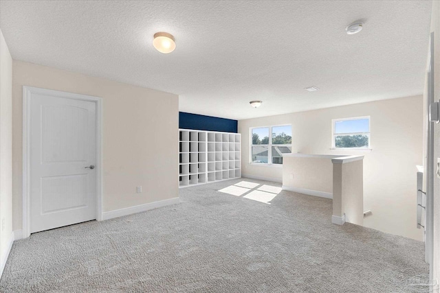 unfurnished room with carpet floors and a textured ceiling