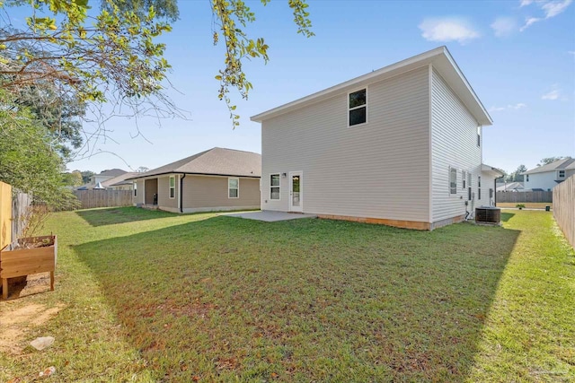 rear view of property with a yard, a patio, and central AC unit