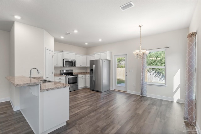 kitchen featuring kitchen peninsula, stainless steel appliances, sink, dark hardwood / wood-style floors, and white cabinetry