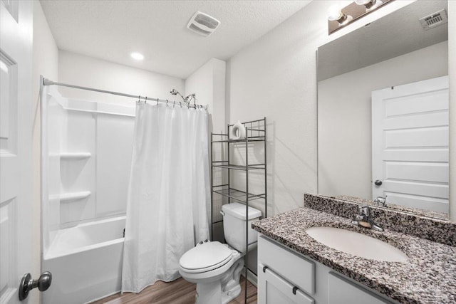 bathroom featuring toilet, visible vents, wood finished floors, and vanity