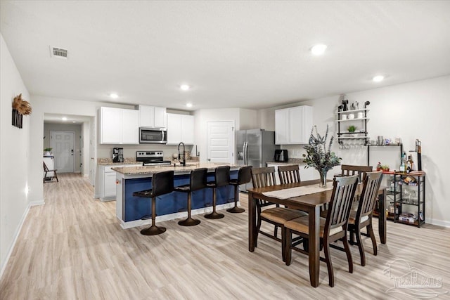 dining space with light wood finished floors, baseboards, visible vents, and recessed lighting