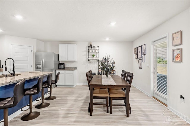 dining room featuring light wood-style floors, baseboards, and recessed lighting
