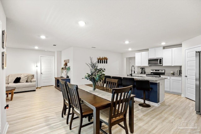 dining room featuring light wood-type flooring and recessed lighting