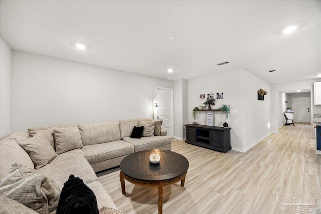 living room with light wood-style floors, visible vents, baseboards, and recessed lighting