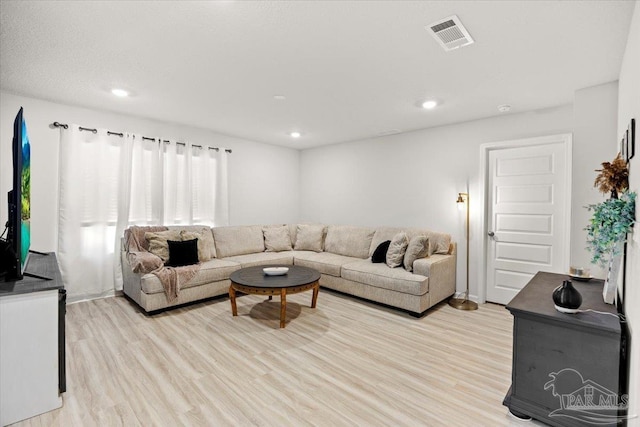 living area with recessed lighting, light wood finished floors, and visible vents
