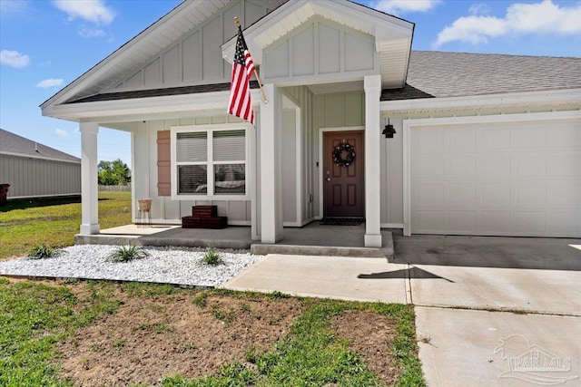 view of front of home with covered porch, roof with shingles, an attached garage, and board and batten siding