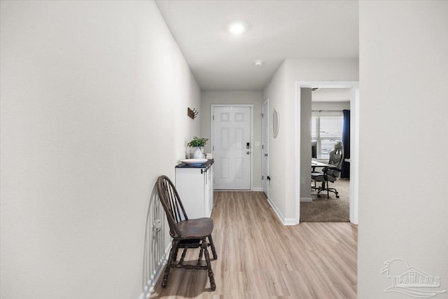 hallway featuring baseboards and light wood-type flooring