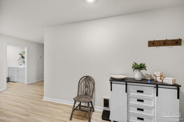 living area with light wood-type flooring and baseboards