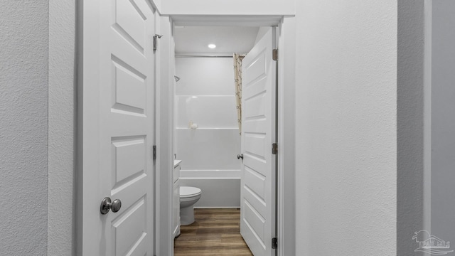 9869 Starling Dr, Pensacola, FL 32506 - full bathroom featuring a textured wall, wood finished floors, toilet, and shower / washtub combination