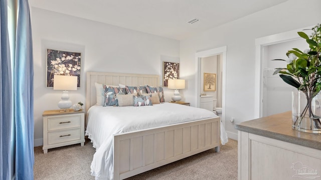 9869 Starling Dr, Pensacola, FL 32506 - bedroom with light carpet, ensuite bath, and baseboards