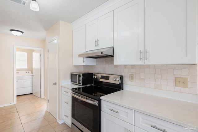 kitchen with visible vents, under cabinet range hood, stainless steel appliances, white cabinets, and washer / dryer