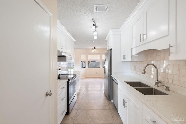 kitchen with a sink, visible vents, white cabinetry, and stainless steel appliances