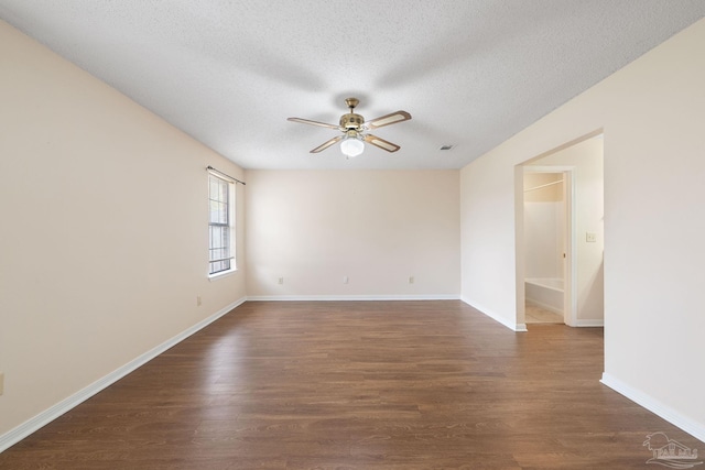 unfurnished room featuring dark wood finished floors, baseboards, a textured ceiling, and a ceiling fan